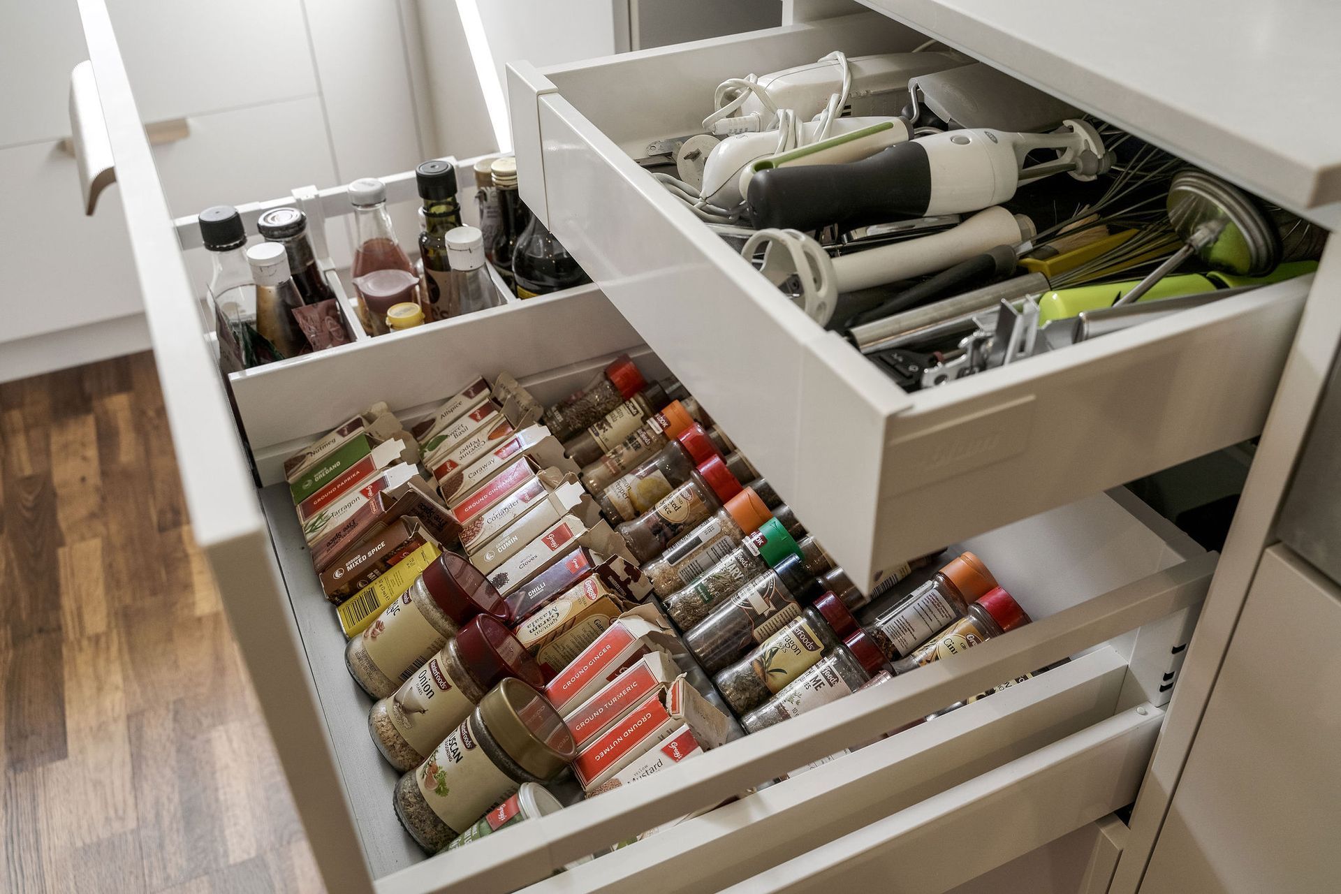 A kitchen drawer filled with spices and utensils