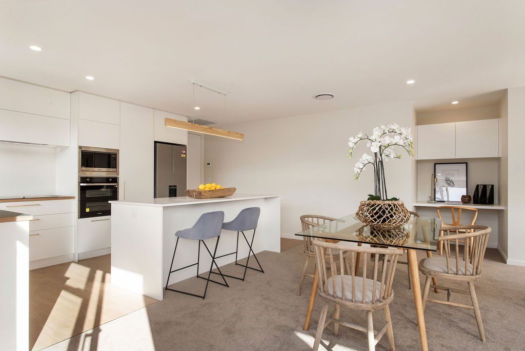 A kitchen and dining room in a house with a table and chairs.
