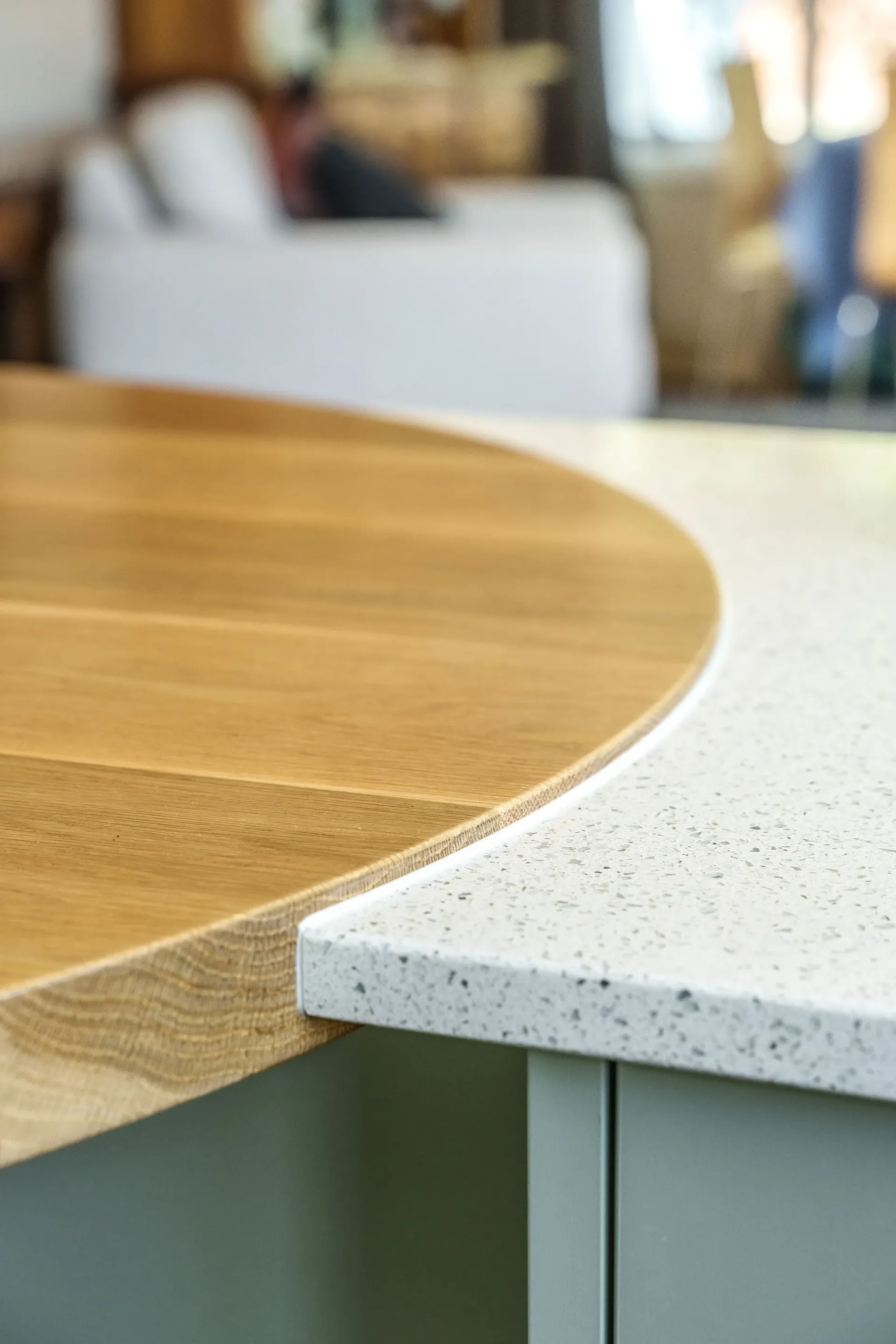 A wooden table with a white counter top in a kitchen.