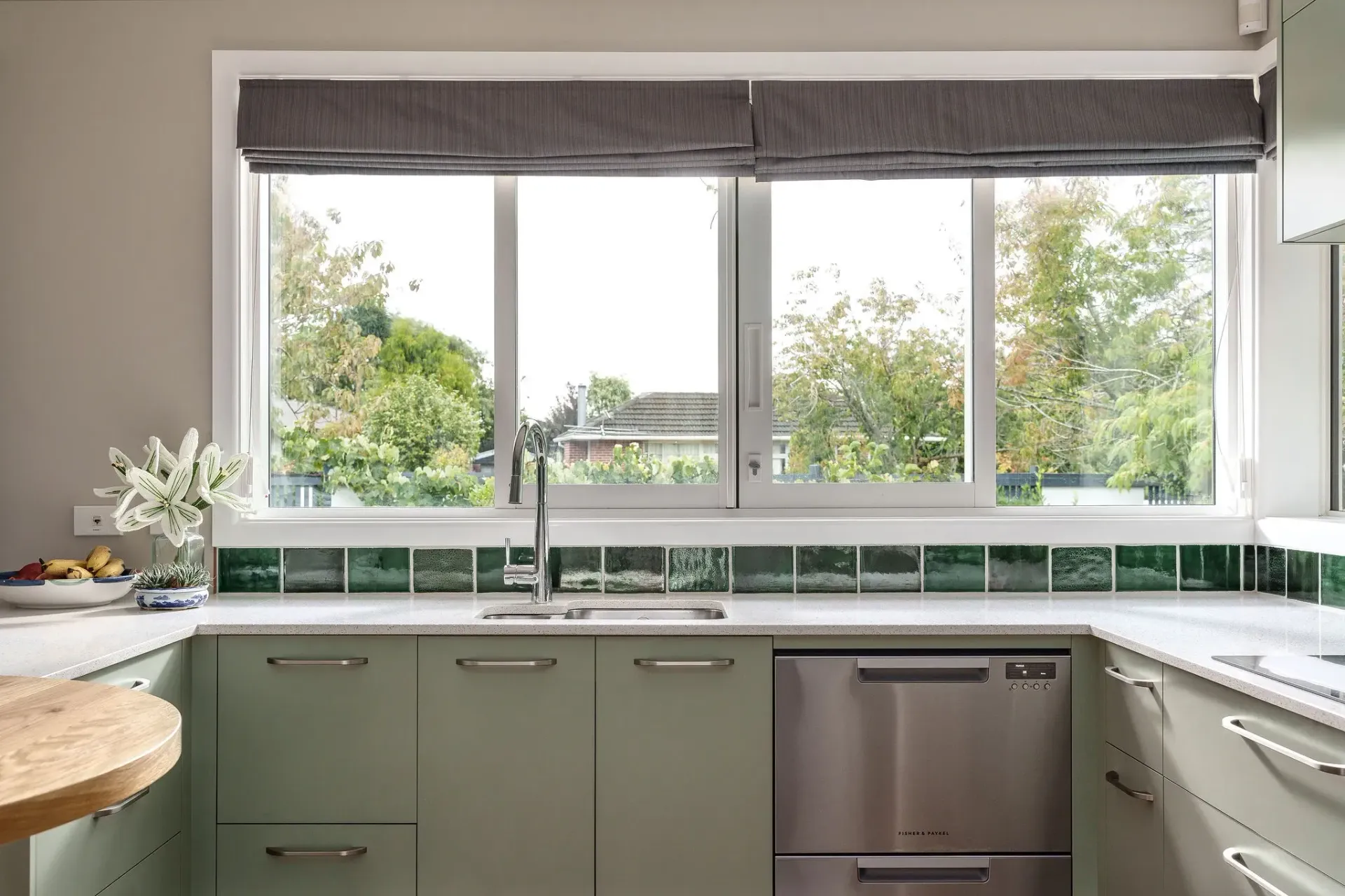 A kitchen with stainless steel appliances and a large window
