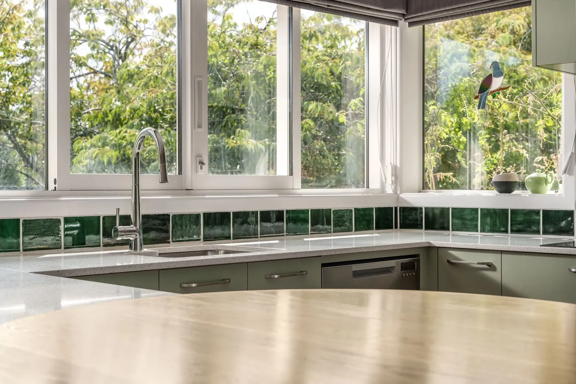 A kitchen with a wooden counter top and a large window.