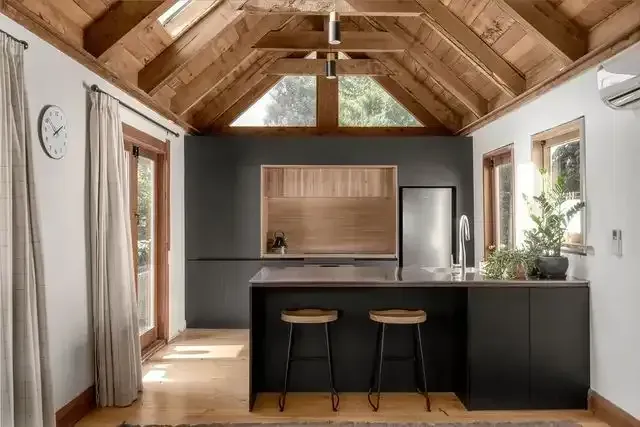 A kitchen with a wooden ceiling and stools