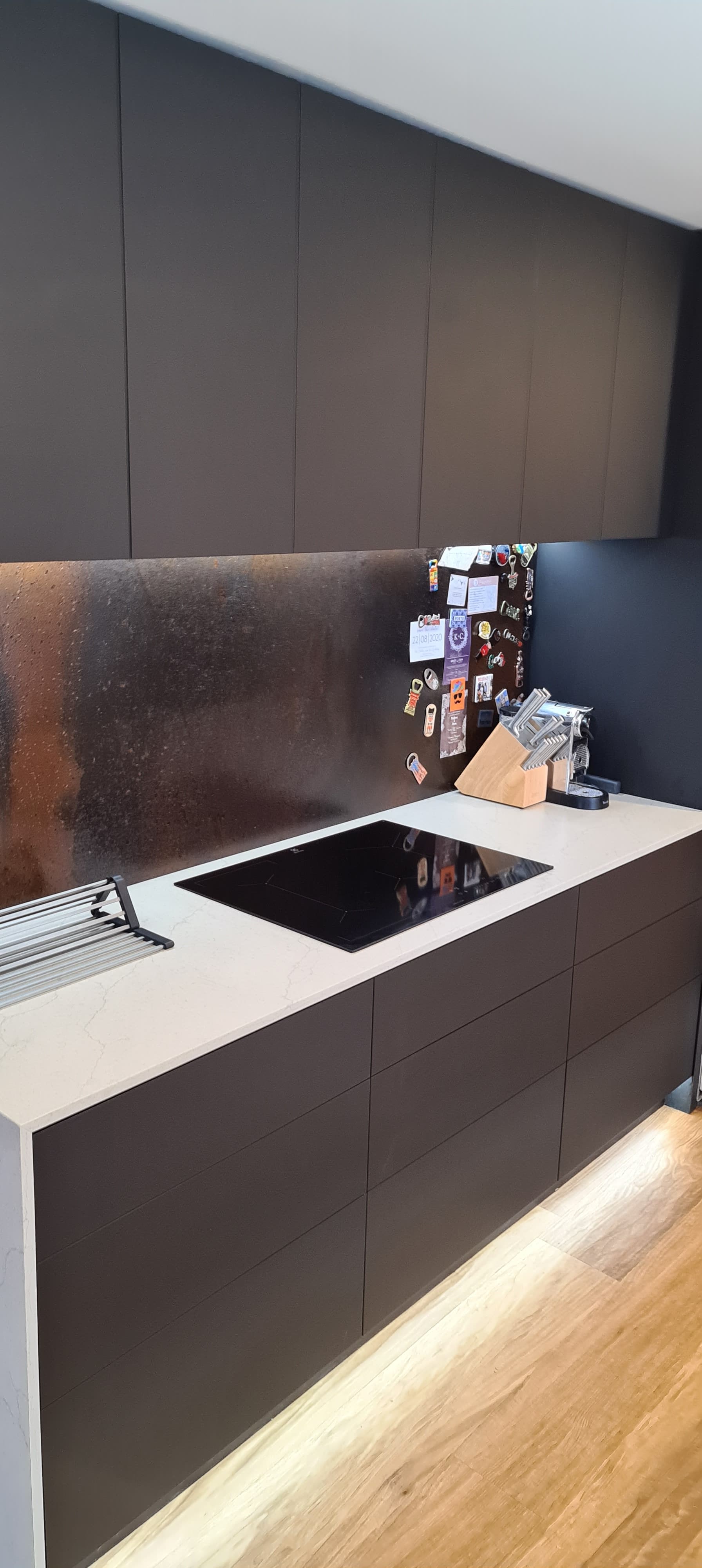 A kitchen with black cabinets and a stove top oven.