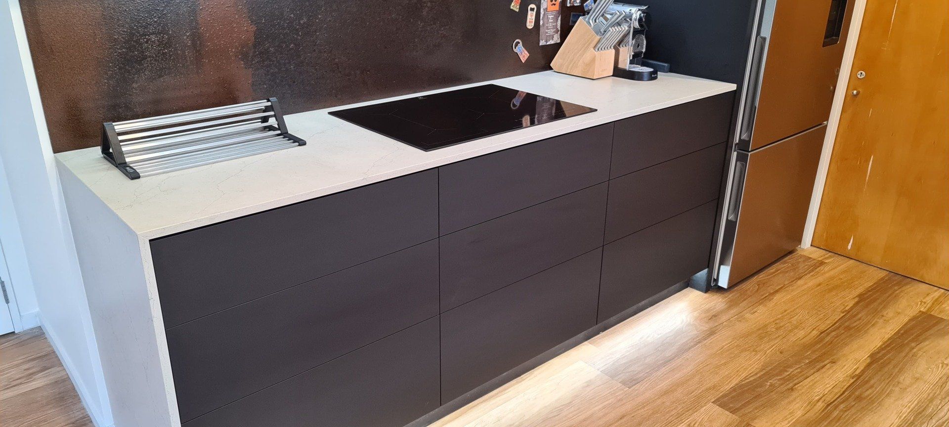 A kitchen with black cabinets and a stove top oven.
