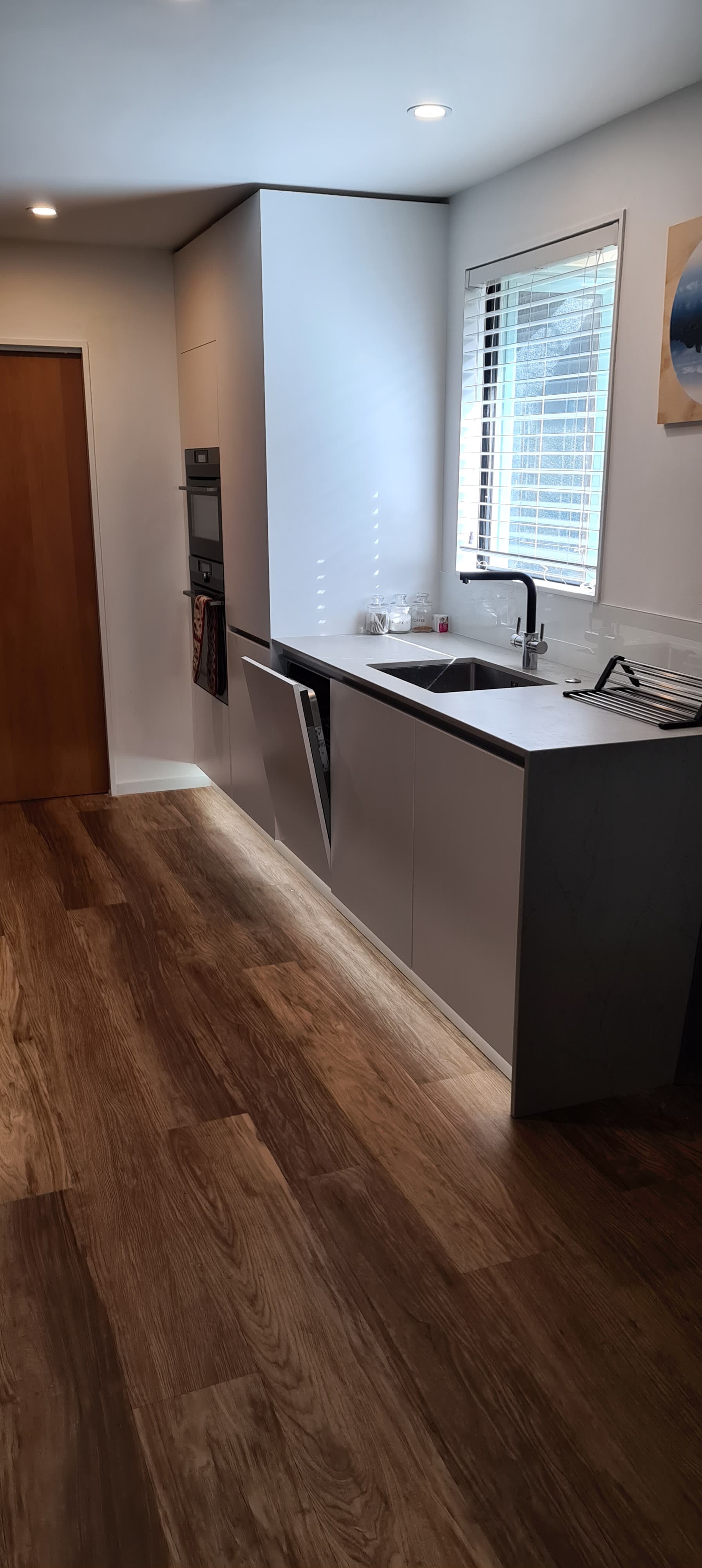 A kitchen with a sink , stove , and window.