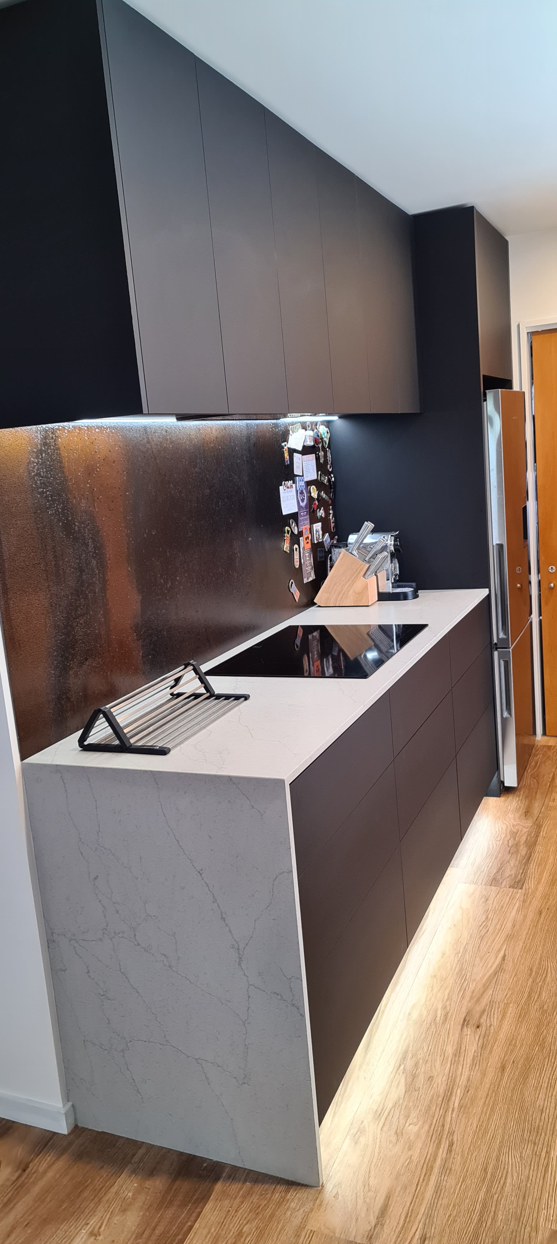 A kitchen with a sink , stove , and refrigerator.
