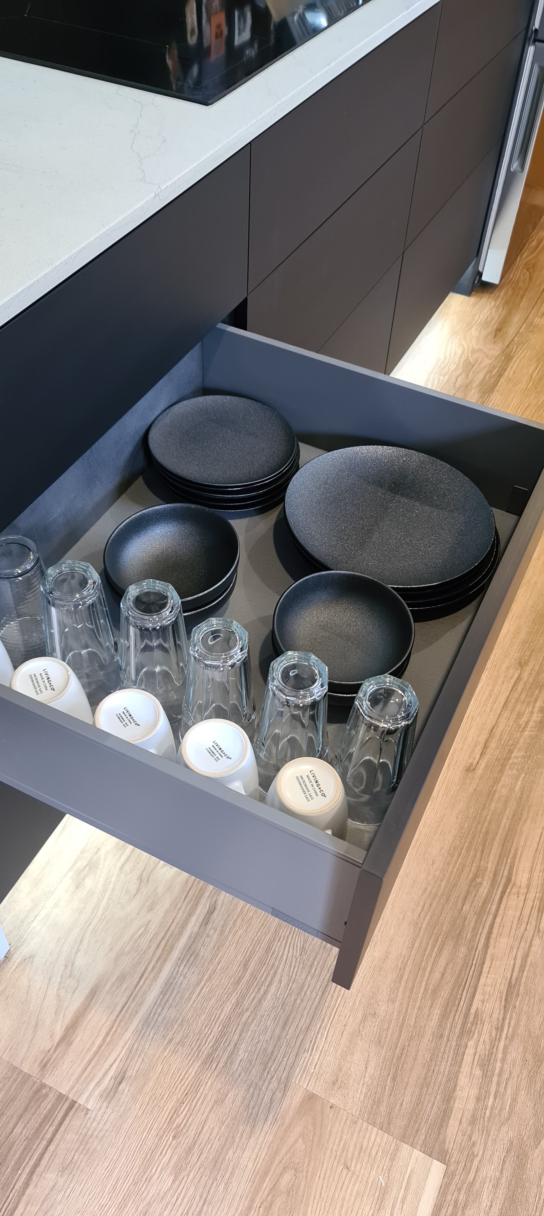 A kitchen drawer filled with plates and glasses.