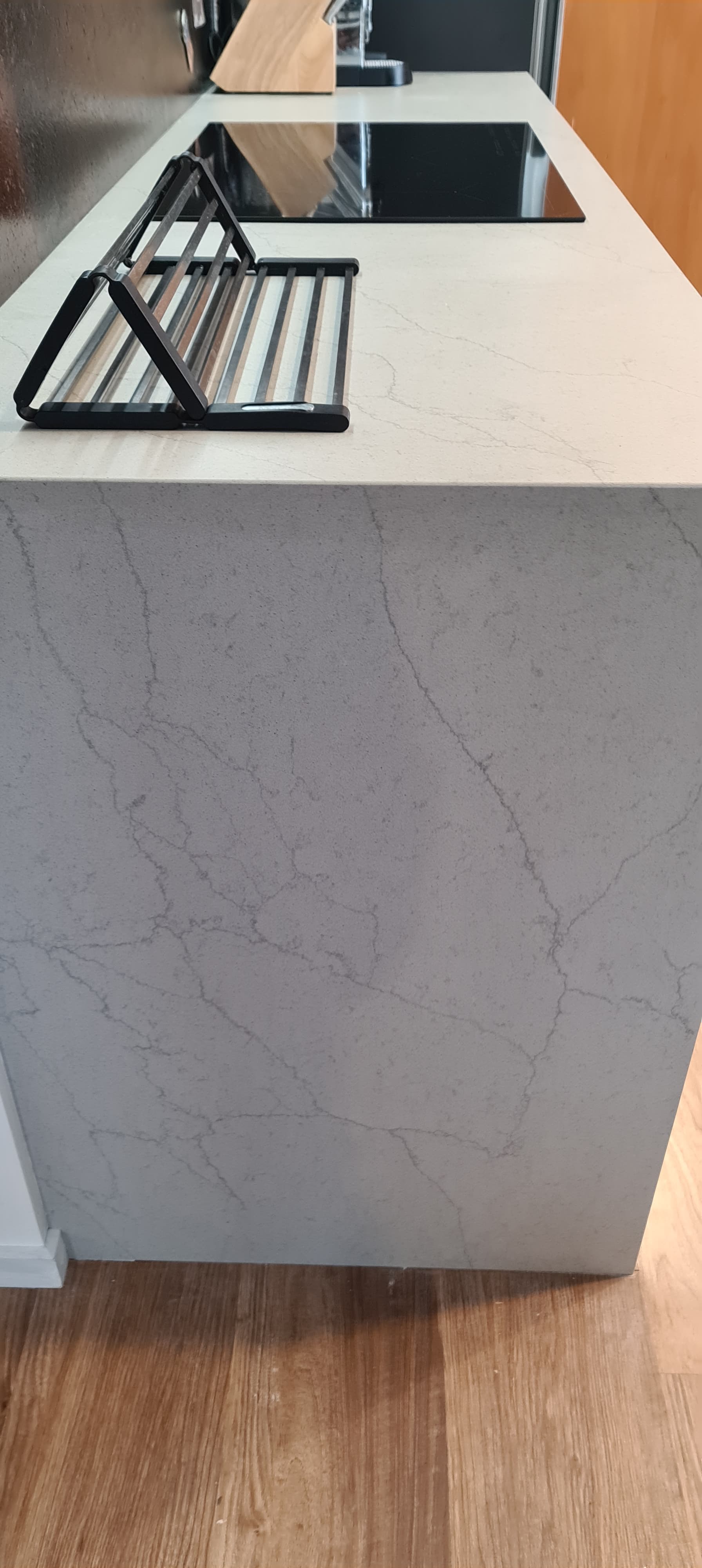 A kitchen island with a stove top oven and a drying rack.