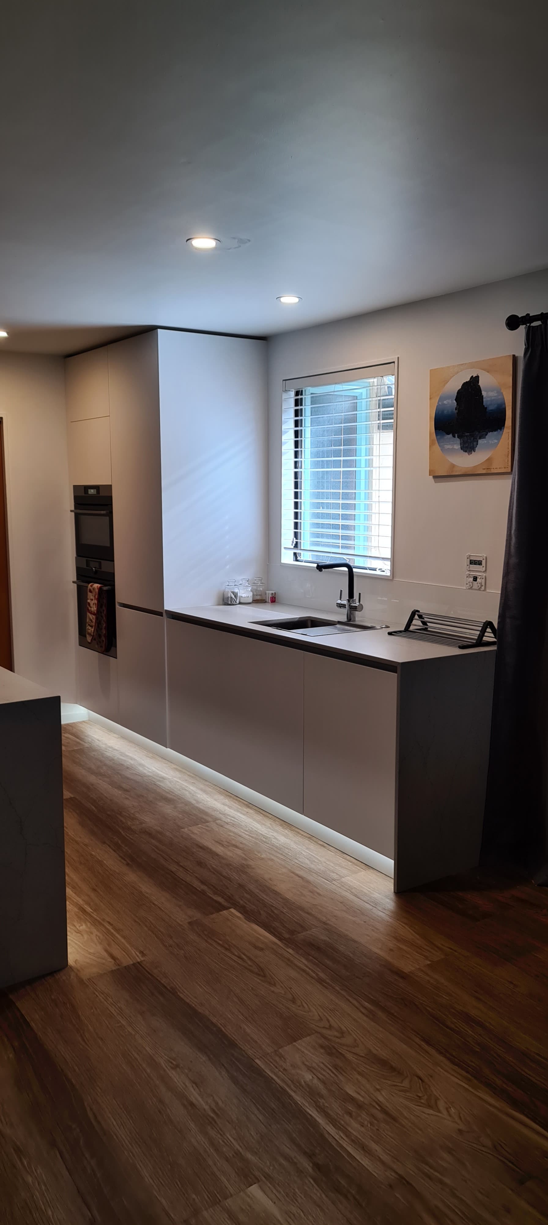 A kitchen with a sink , counter , and window.