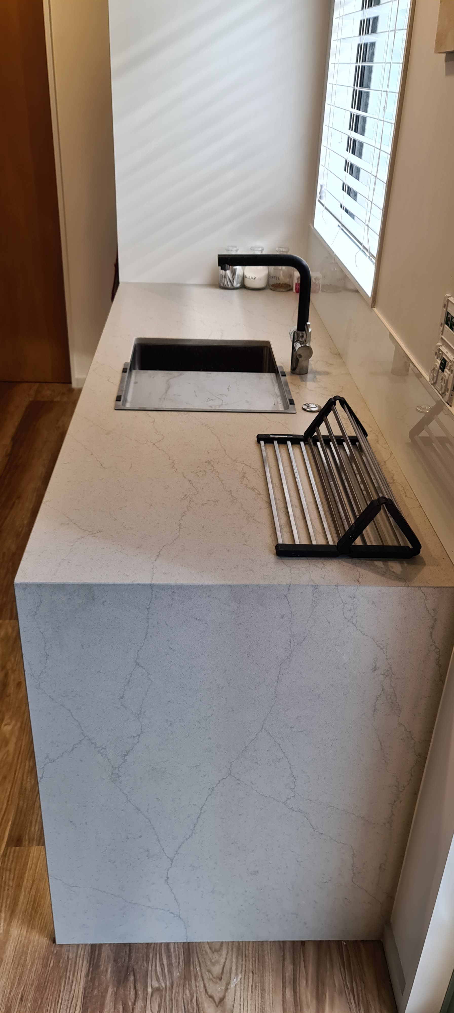A kitchen counter with a sink and a keyboard on it.