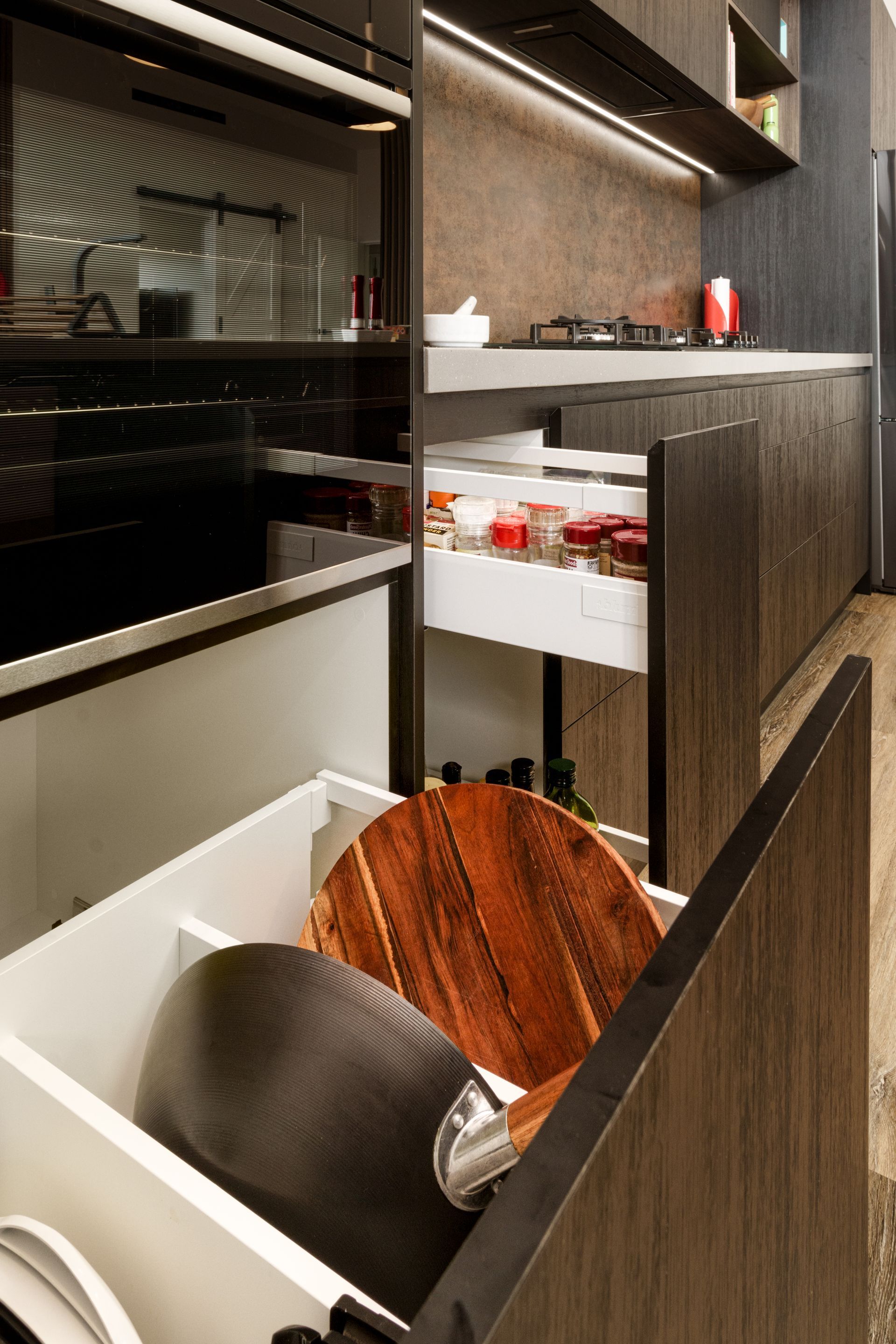 A kitchen with a wooden cutting board in a drawer.