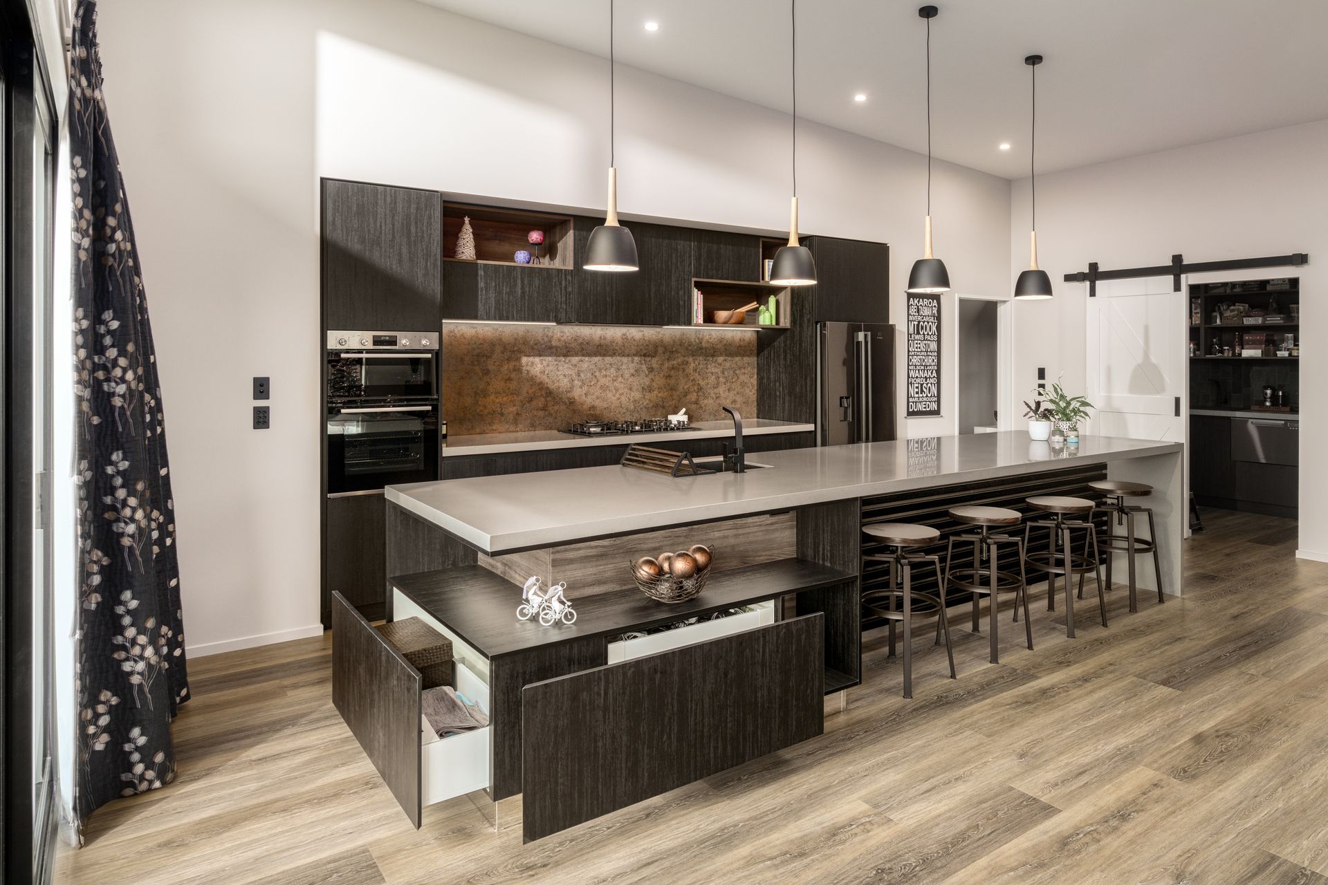 An artist 's impression of a kitchen with a large island and stools.
