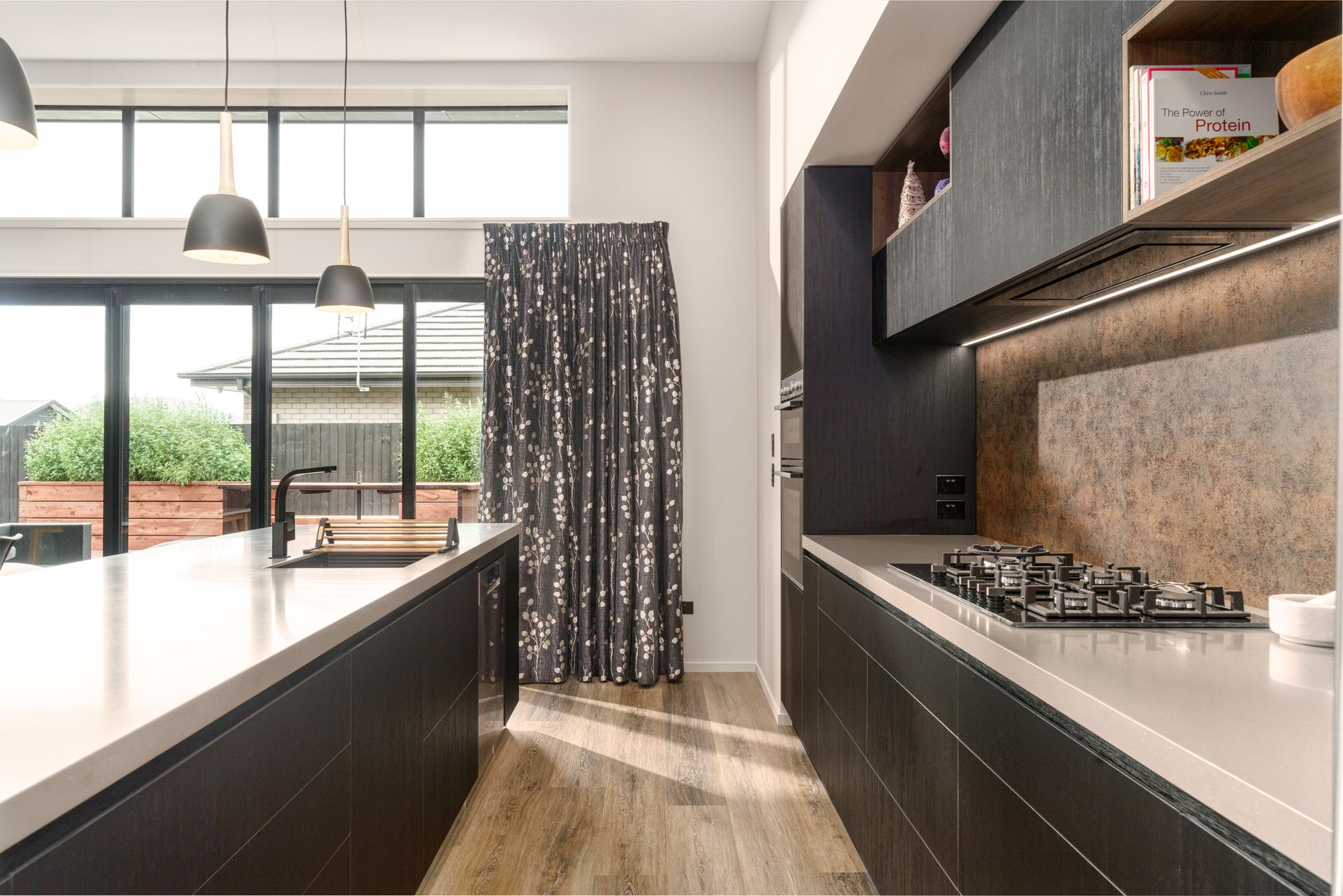A kitchen with a large island and a stove top oven.