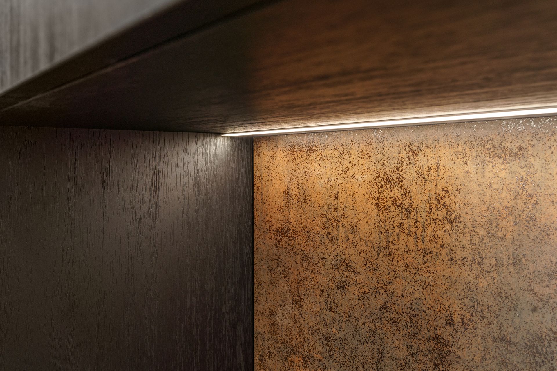 A close up of a wooden shelf with a light on it.