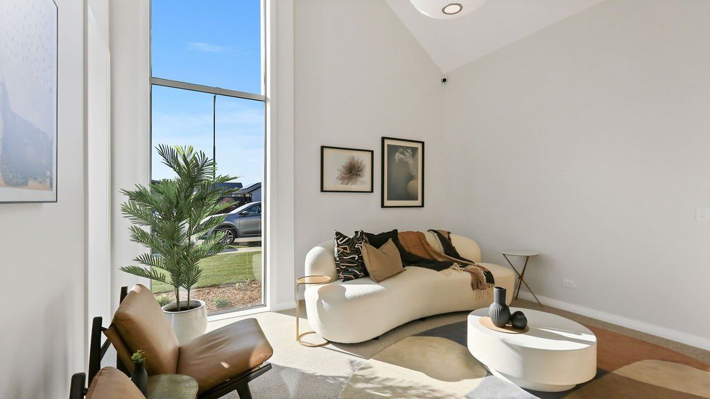 A living room with a couch , chair , table and window.