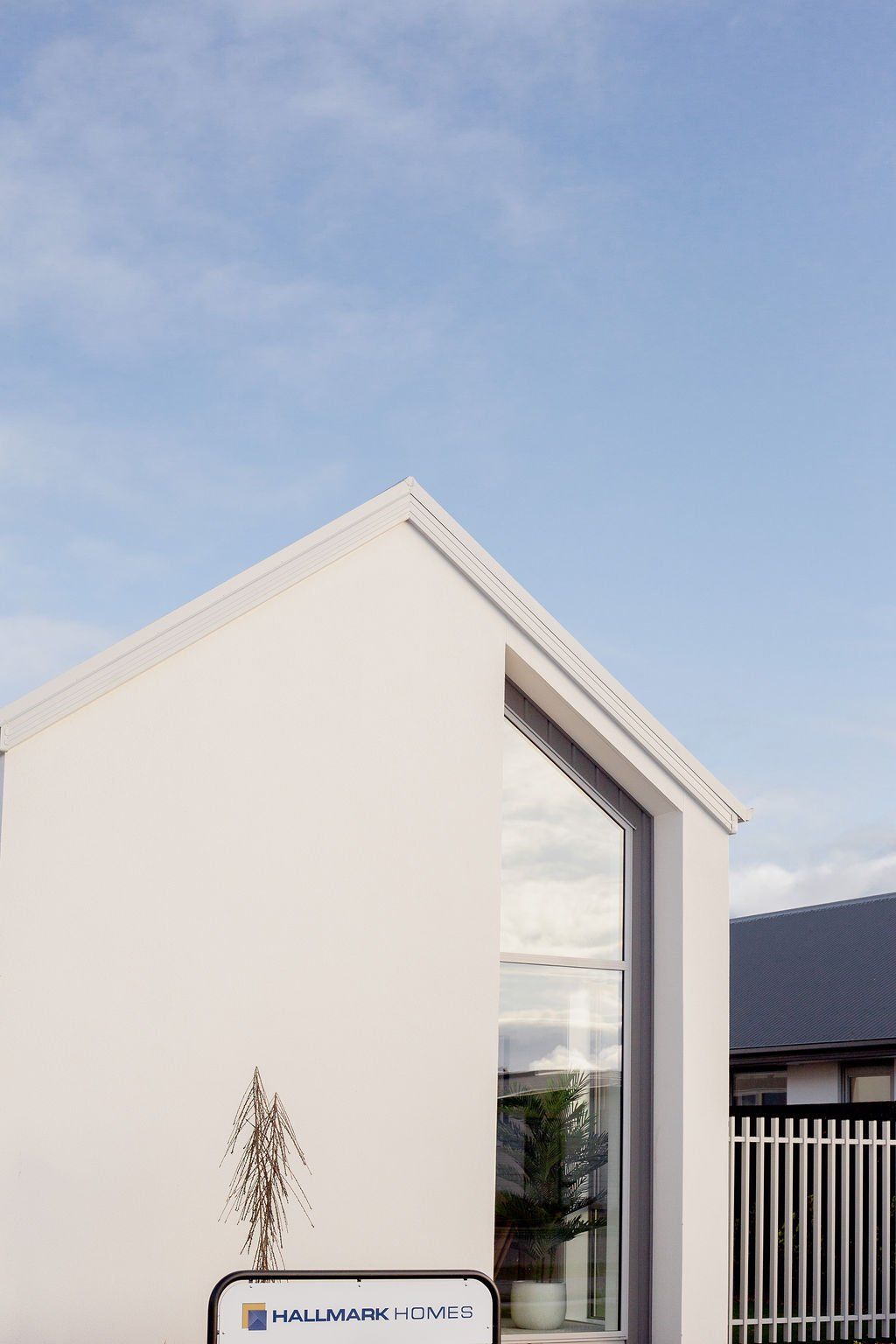 A white house with a blue sky in the background and a large window.
