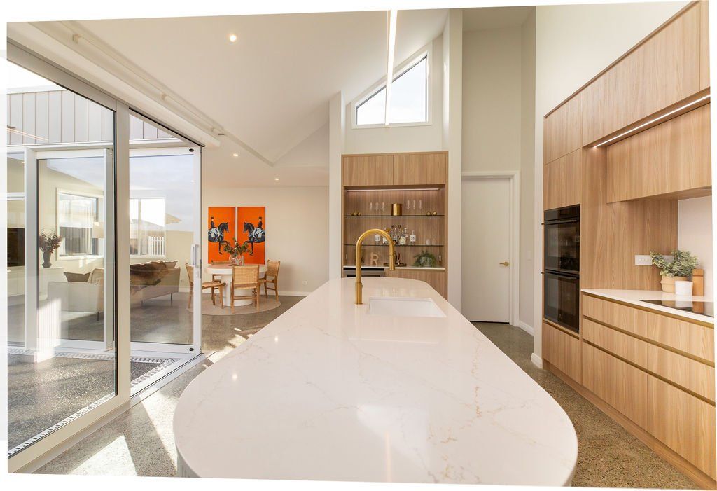 A kitchen with white counter tops and wooden cabinets and a large island.