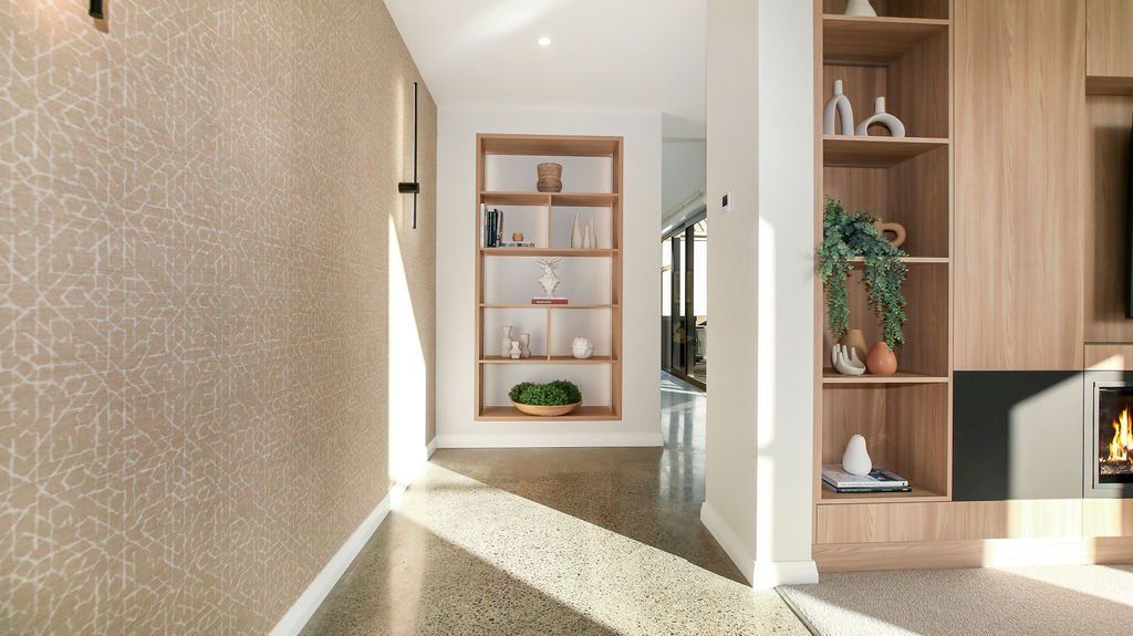 A hallway in a house with a fireplace and shelves