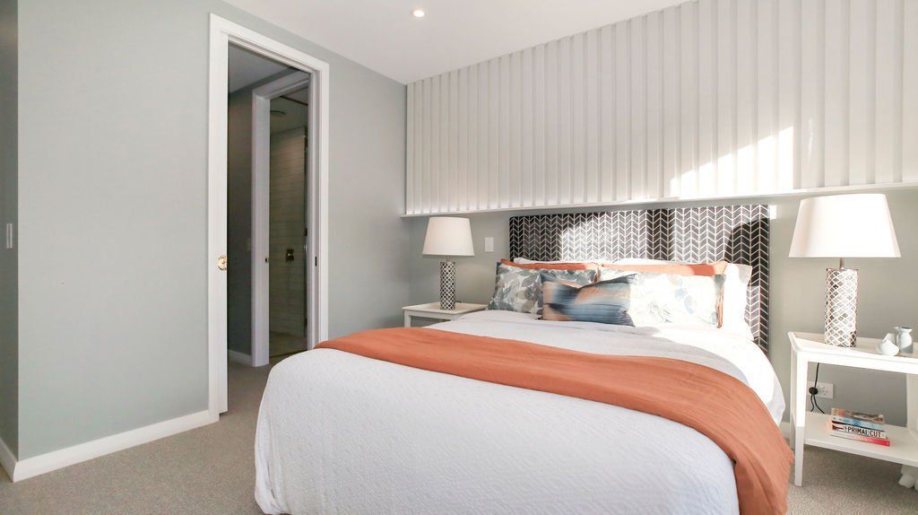 A bedroom with a large bed and two lamps