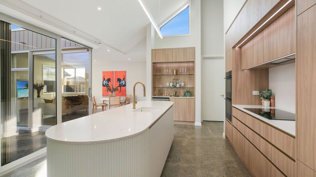A kitchen with a large island in the middle and wooden cabinets.