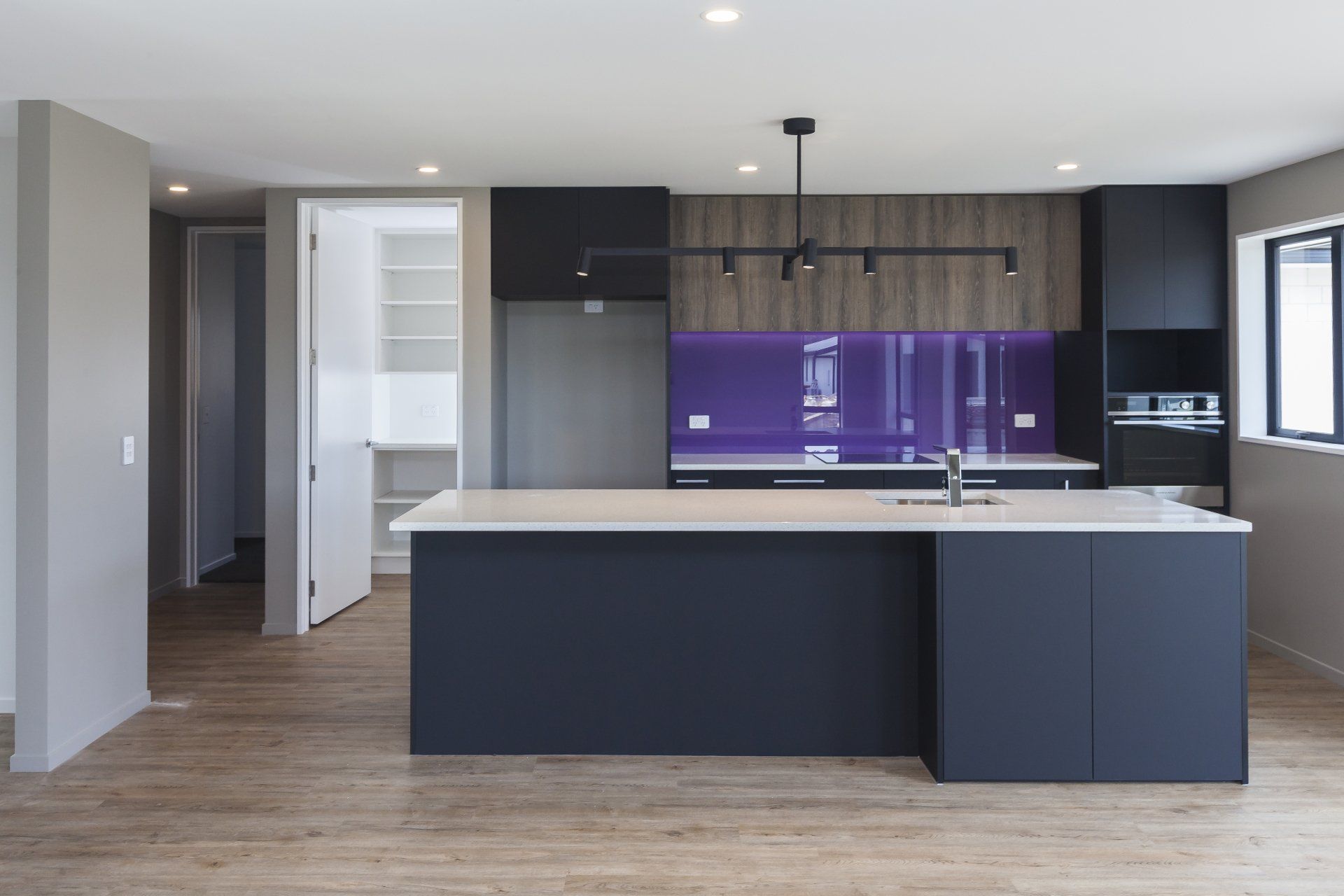 An empty kitchen with a large island in the middle