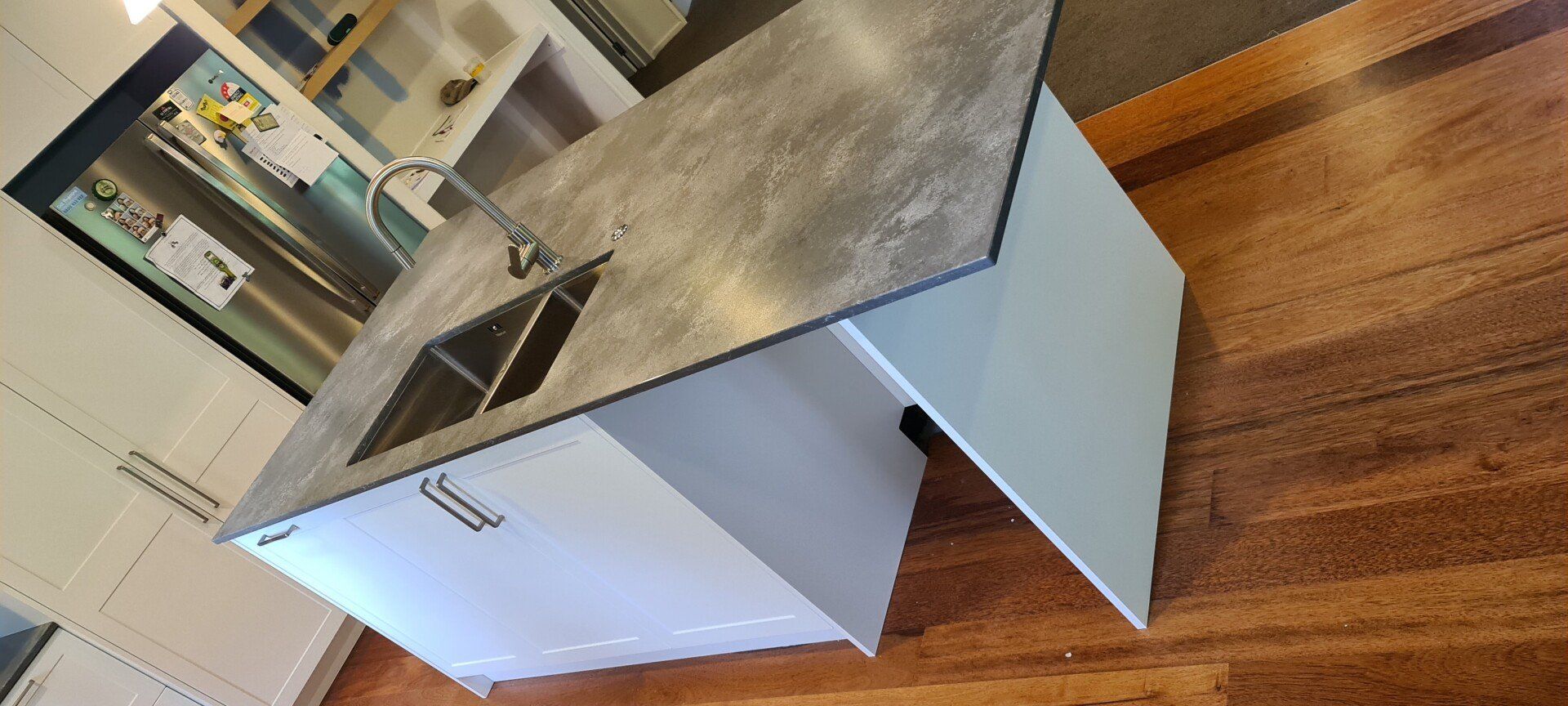 A kitchen with a large island and two sinks.