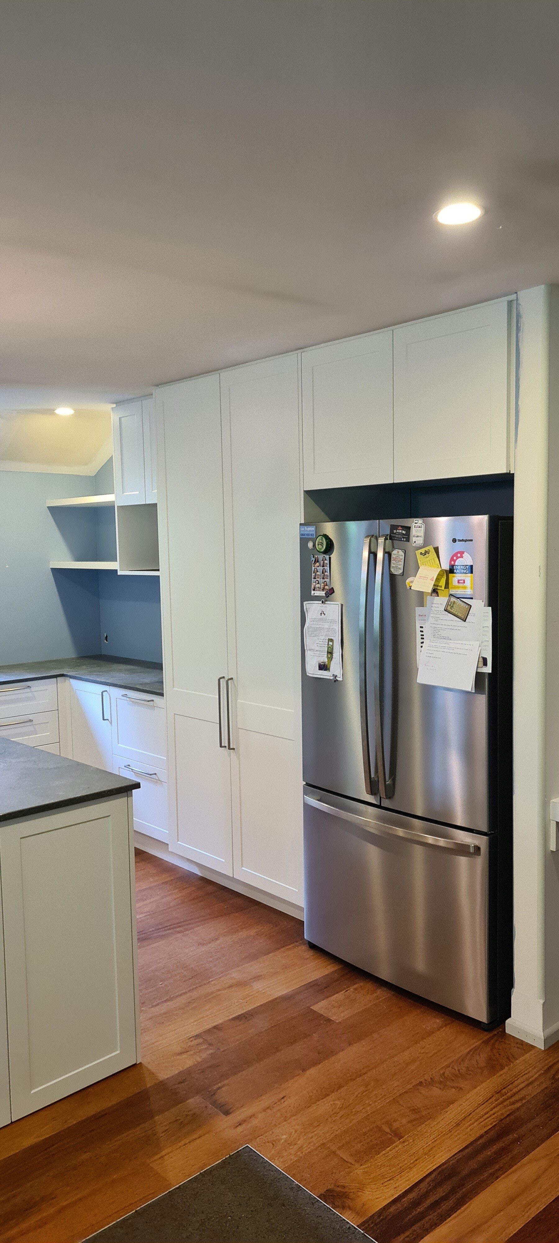 A kitchen with stainless steel appliances and wooden floors.