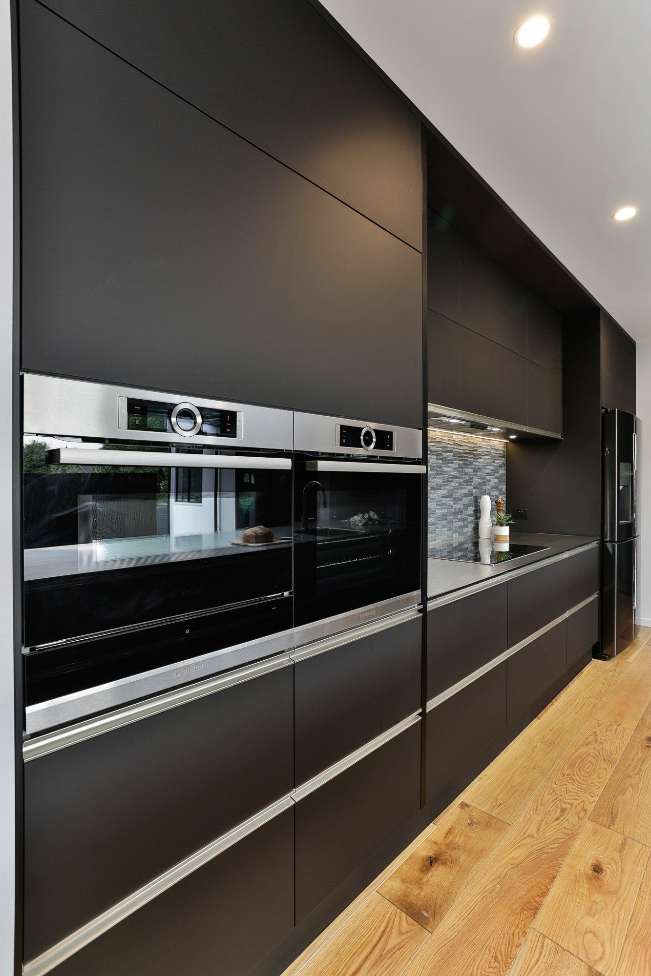 A kitchen with black cabinets and stainless steel appliances