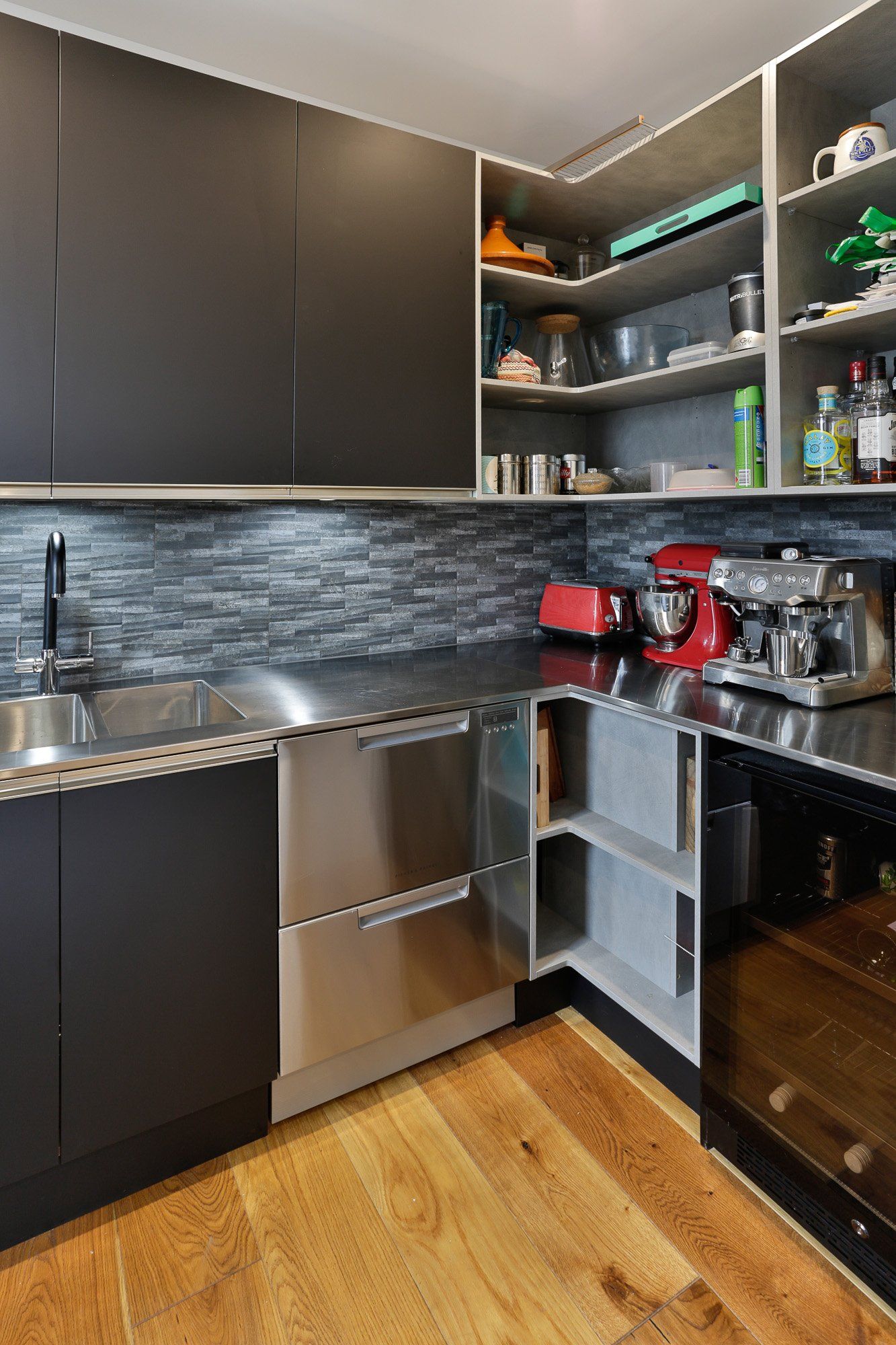 A kitchen with stainless steel appliances and wooden floors.