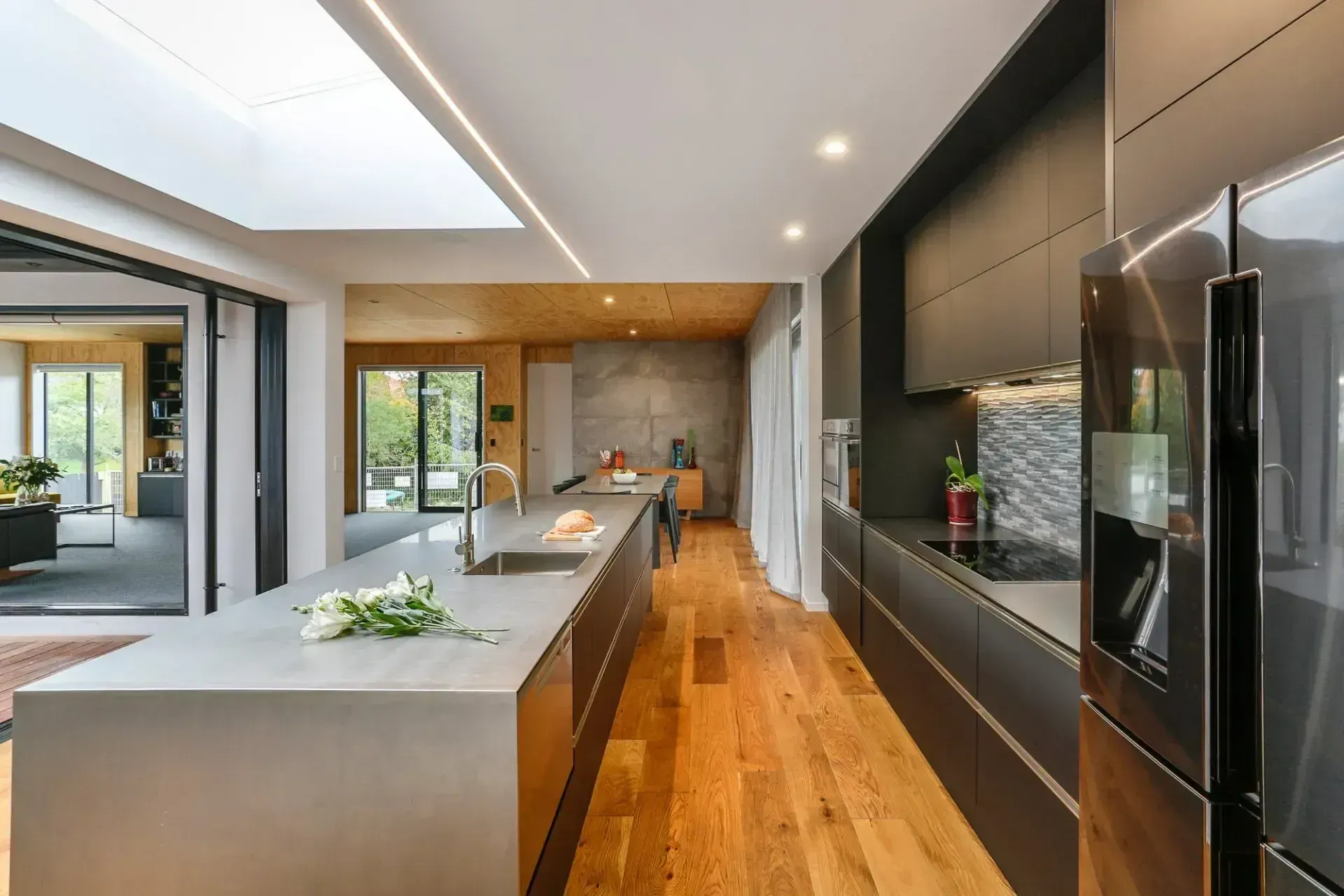 A kitchen with stainless steel appliances and wooden floors.