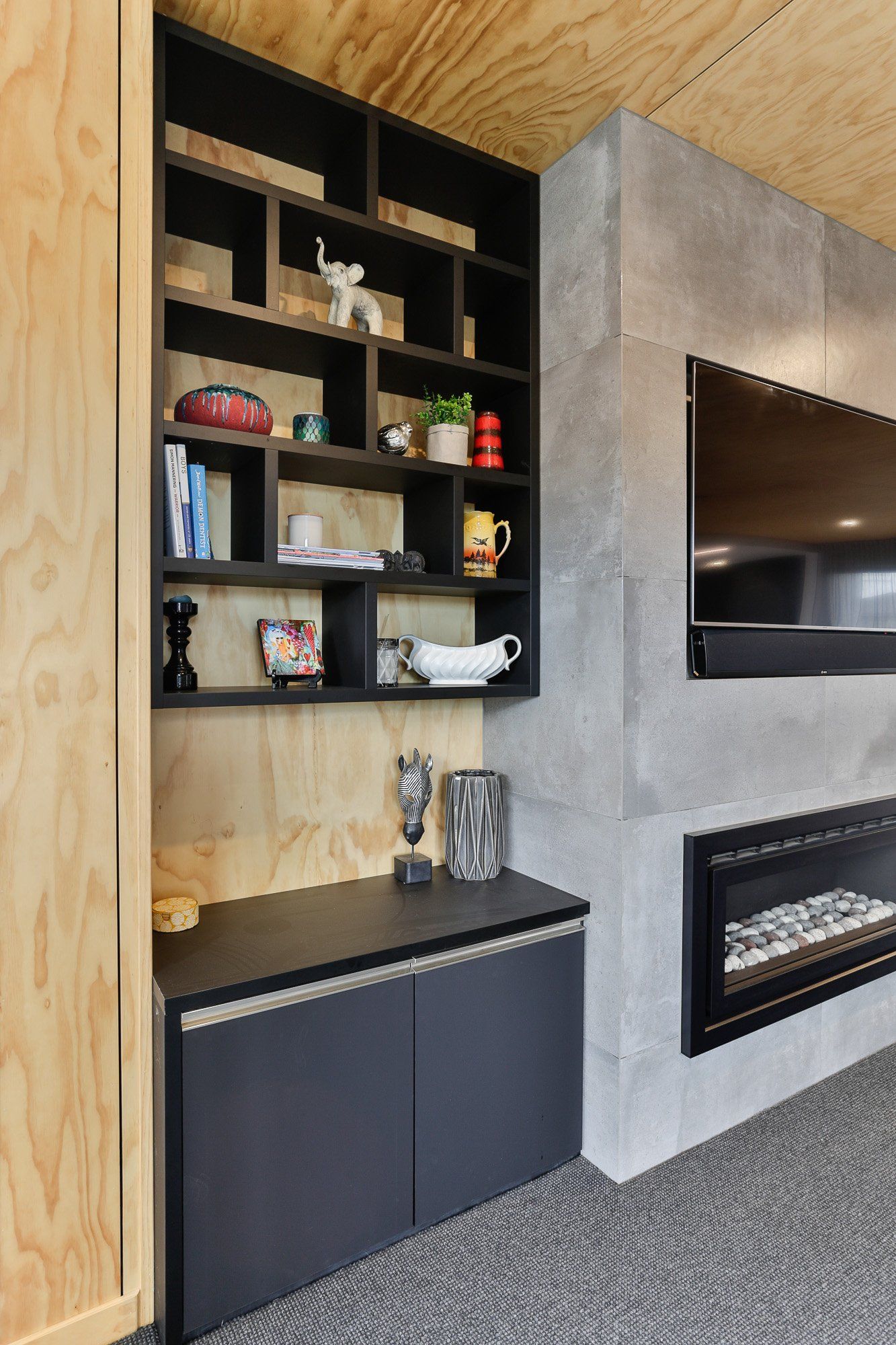 A living room with a fireplace , shelves , and a flat screen tv.