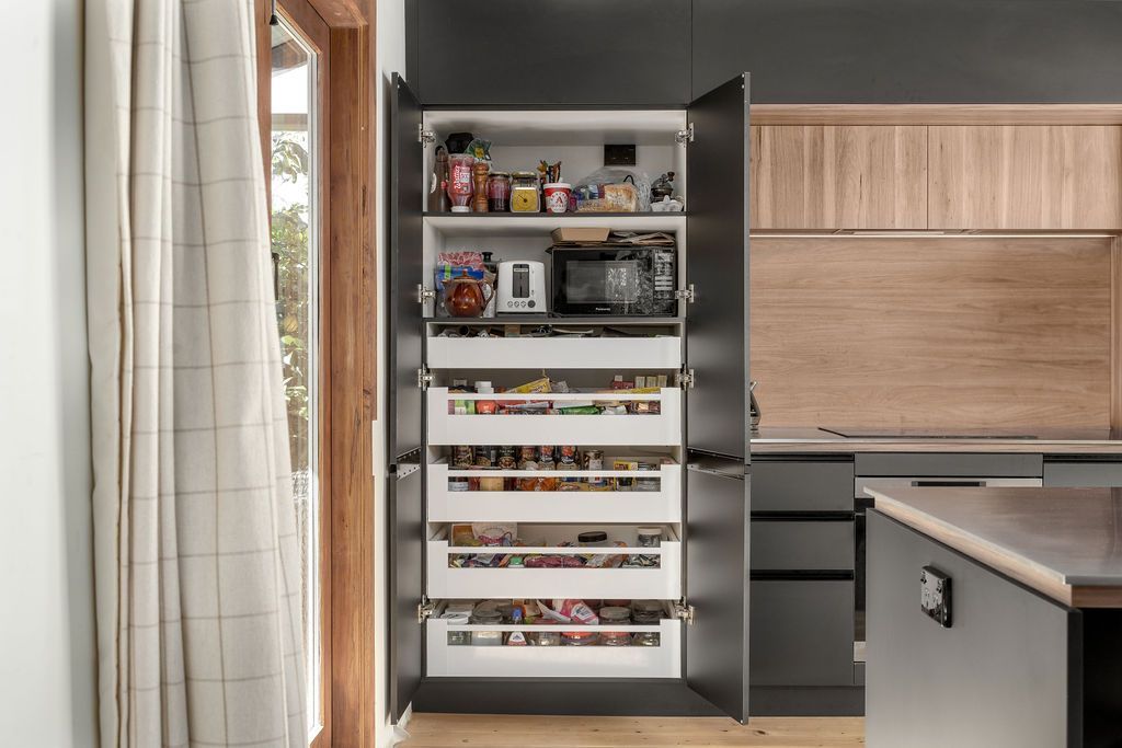 A kitchen with a pantry filled with food and appliances.