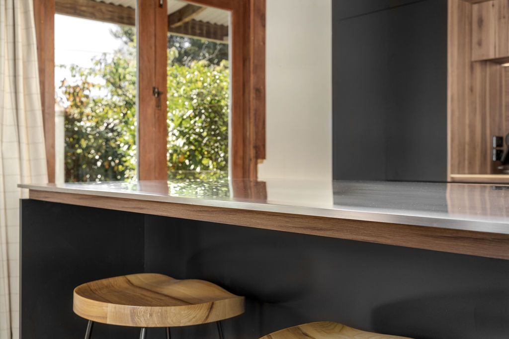 A kitchen with a table and stools and a window.
