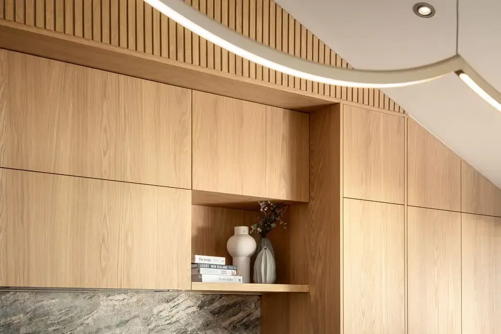 Light wood cabinetry with built-in shelf; modern design; overhead light.