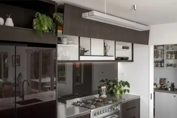 A kitchen with stainless steel appliances and black cabinets.