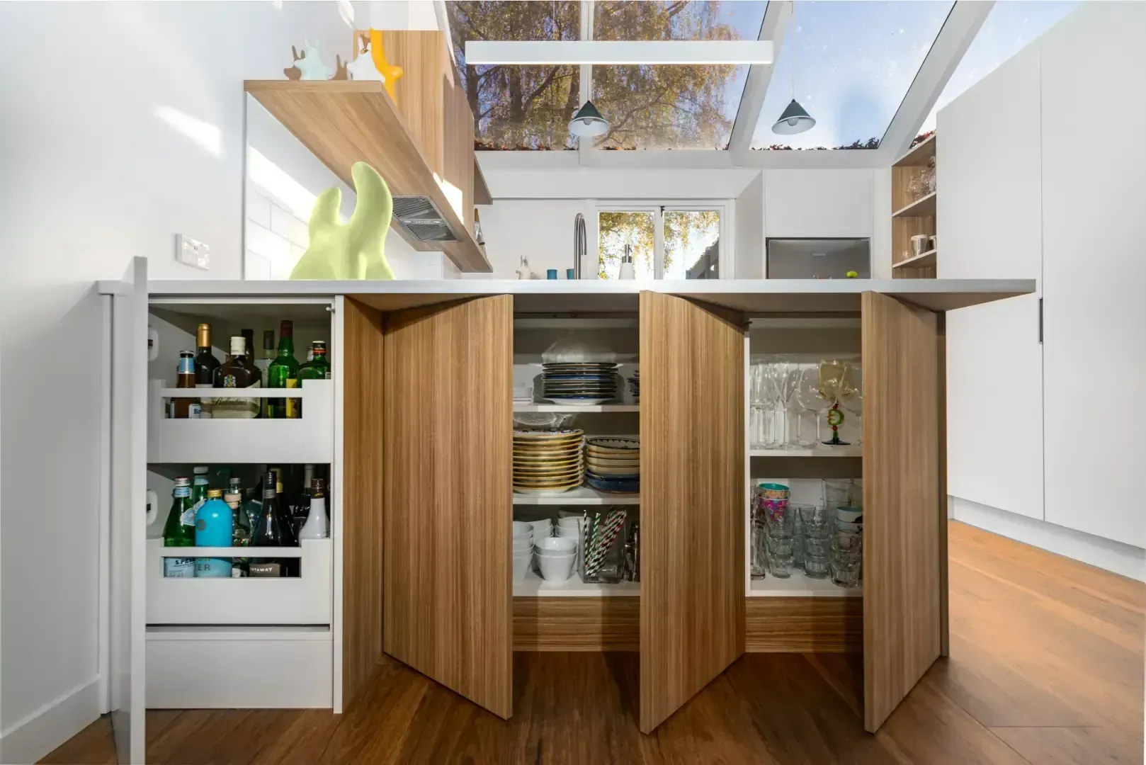 A kitchen with wooden cabinets and drawers with the doors open