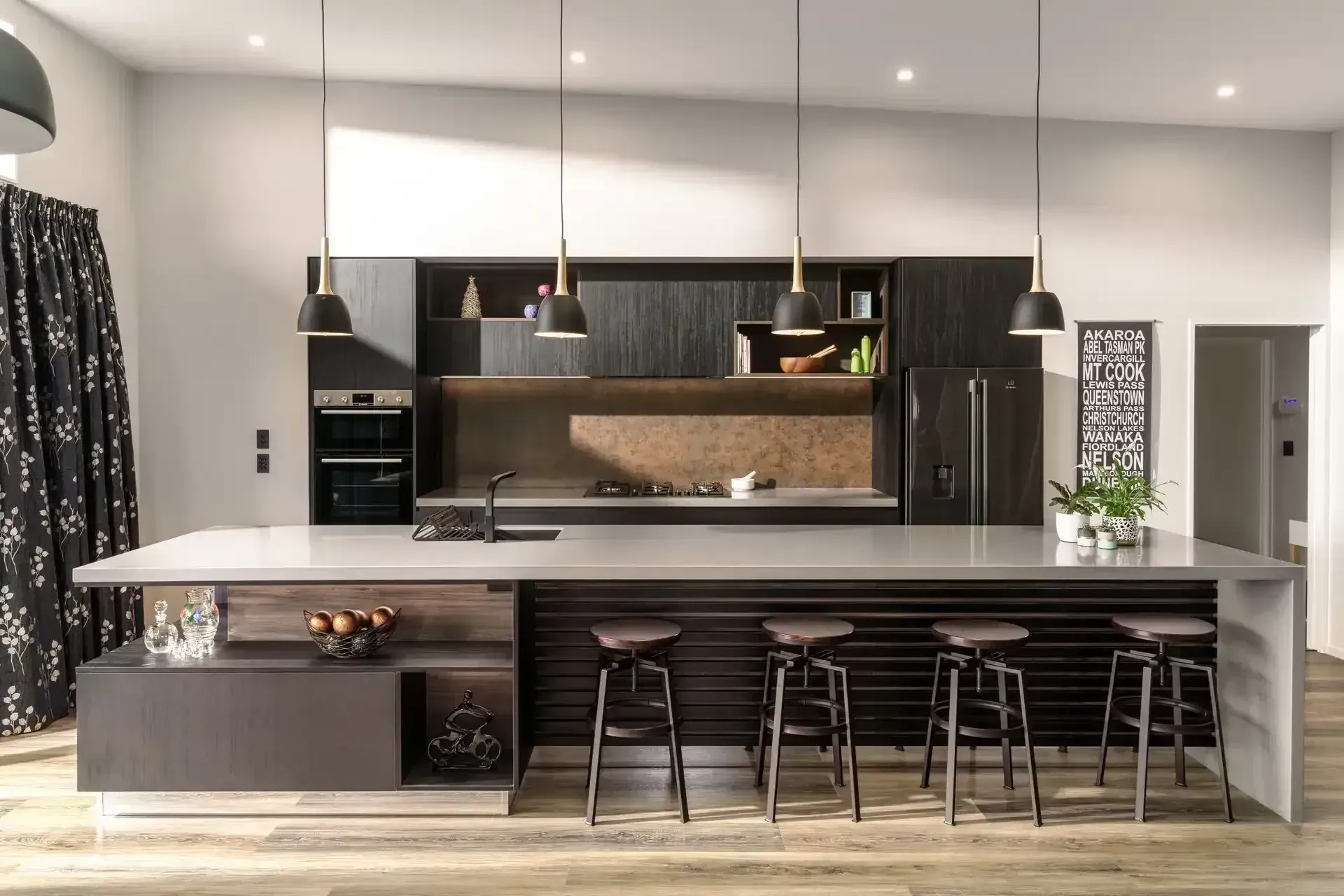 Modern kitchen with dark wood cabinetry, large island with seating, pendant lights.