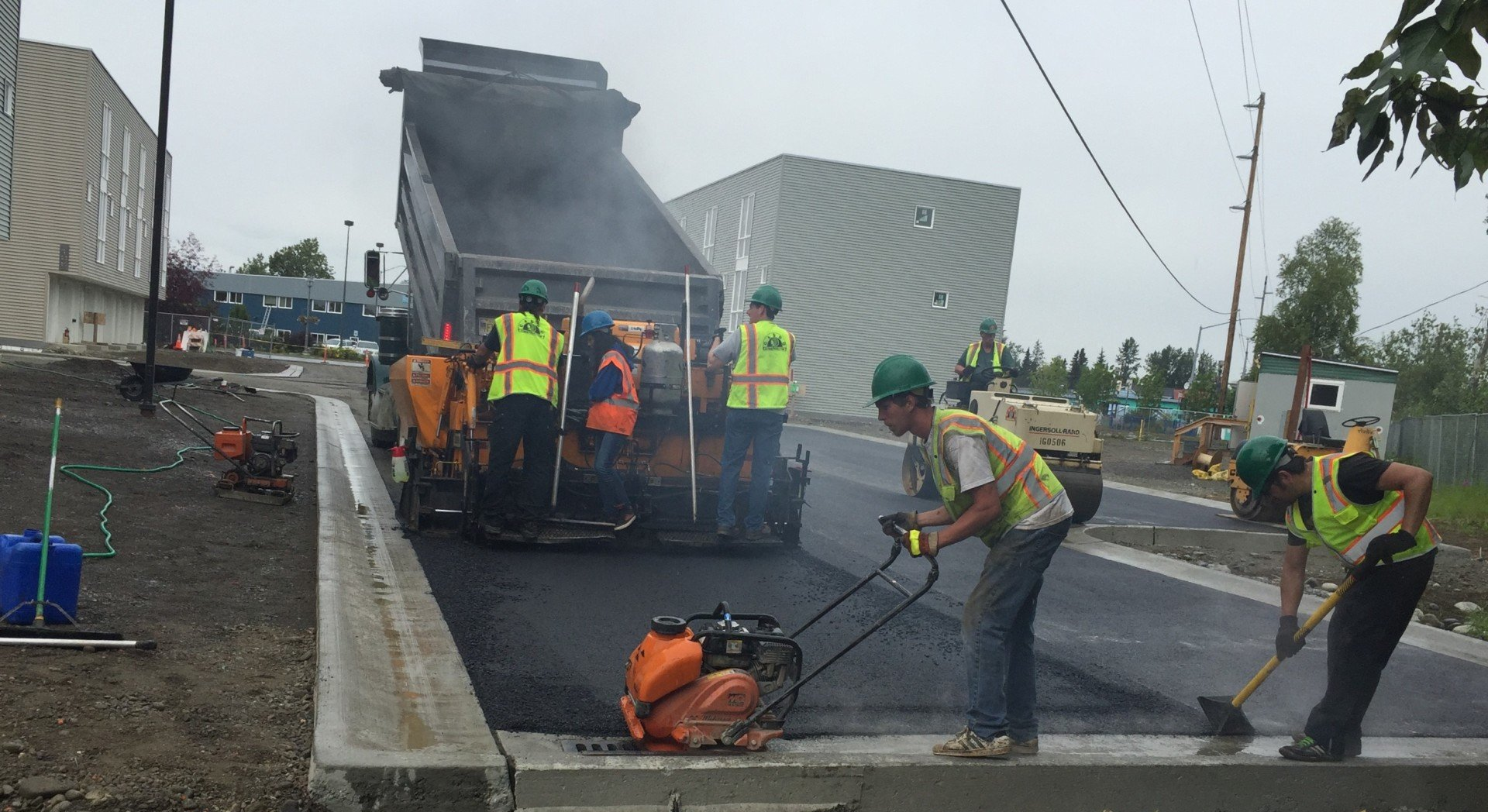 A group of construction workers are working on a road.