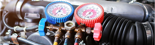 Two gauges are sitting on top of a car engine. | TIRE NATION & AUTO REPAIR POINT S