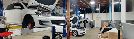 A white car is sitting on a lift in a garage. | TIRE NATION & AUTO REPAIR POINT S