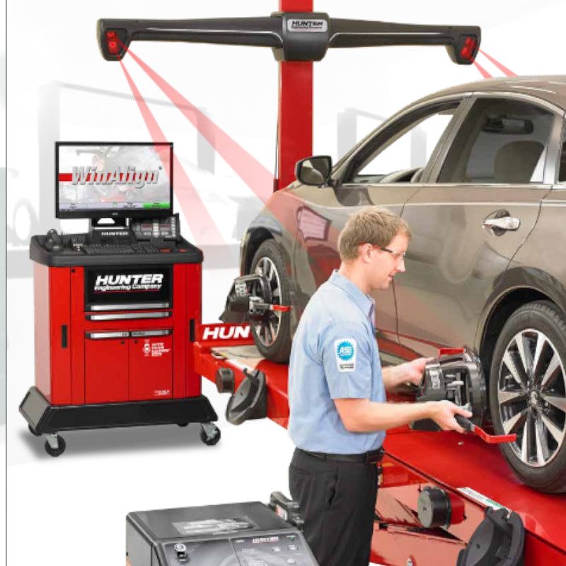 A man is working on a car with a hunter alignment machine | TIRE NATION & AUTO REPAIR POINT S