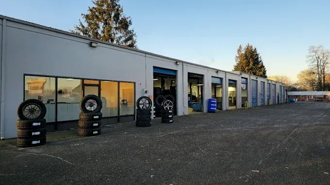 A row of tires are stacked in front of a tire shop. | TIRE NATION & AUTO REPAIR POINT S