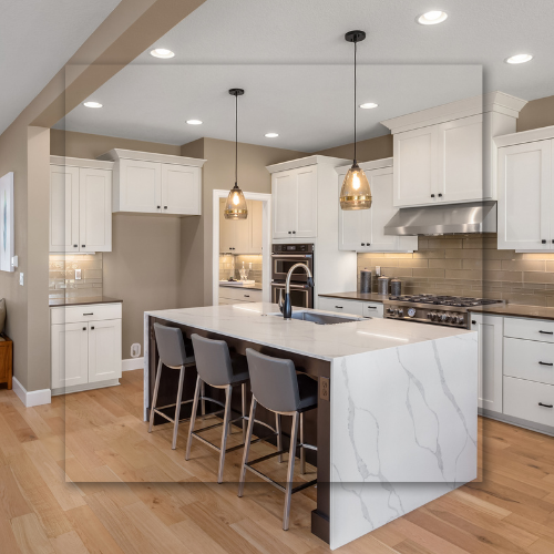 Modern kitchen with white cabinets, large island with seating, pendant lights, and stainless steel appliances.