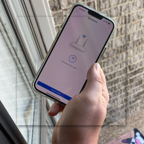 Person using a smartphone to control a smart home; blue icons connect to a house, illustrating automation.