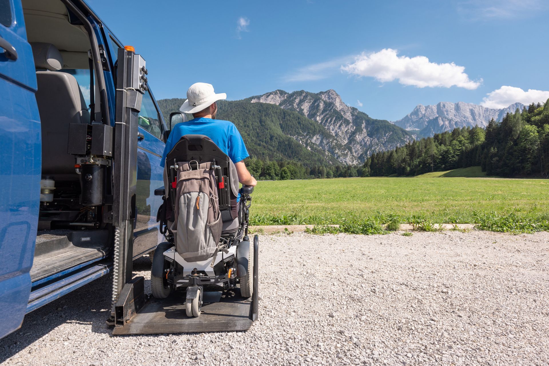 Accessible bathroom with toilet, sink, and grab bars. White tiles and fixtures.