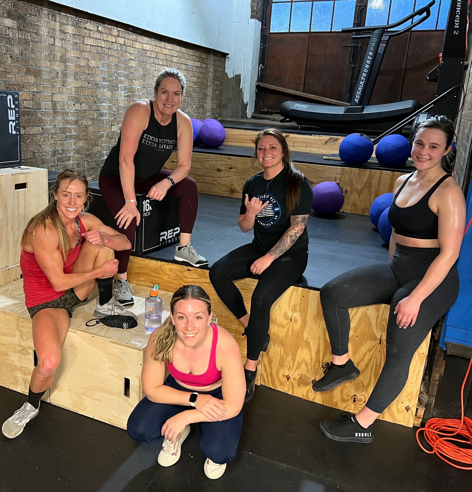 A group of women are posing for a picture in a gym