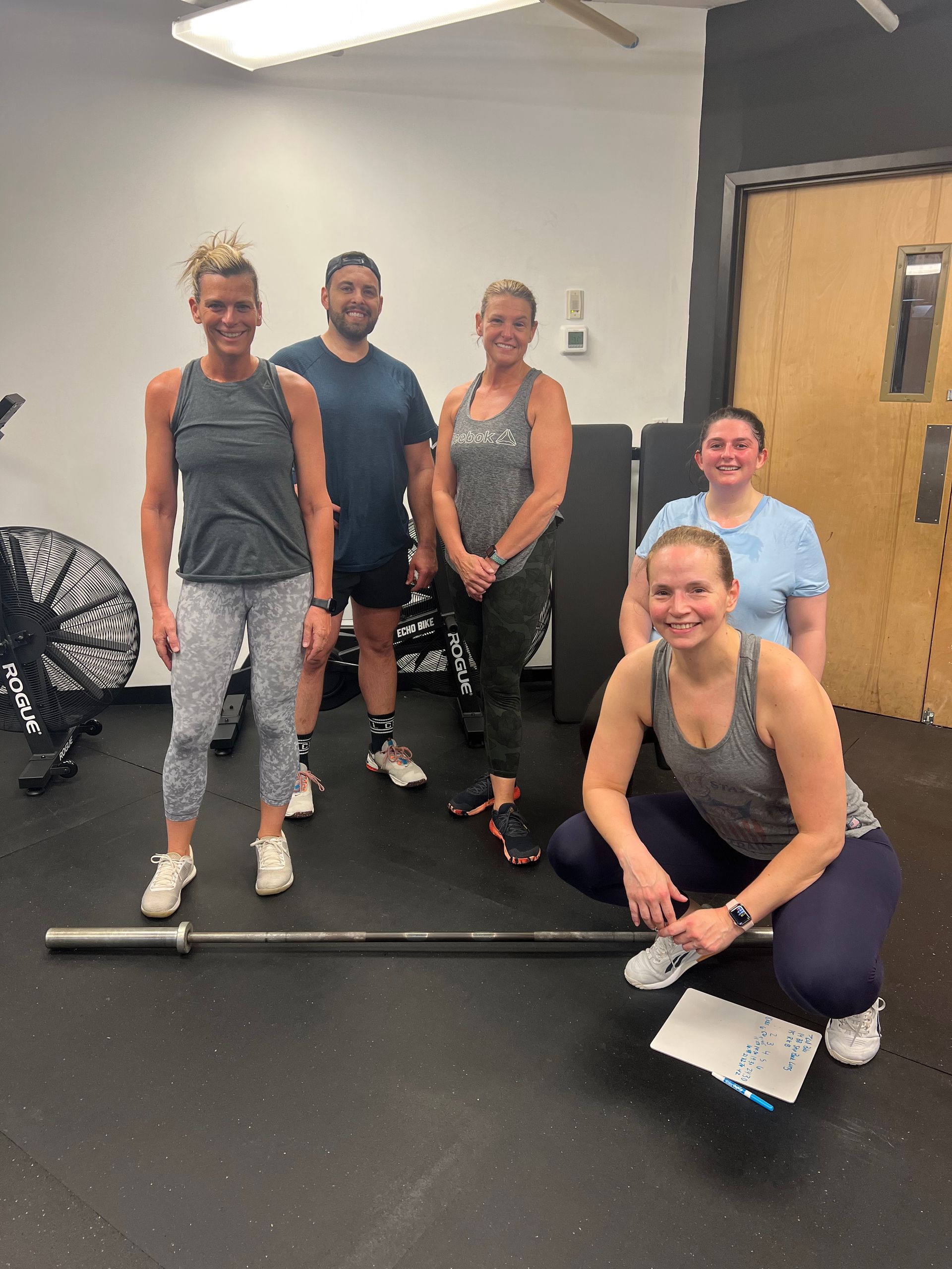 A group of people are posing for a picture in a gym.