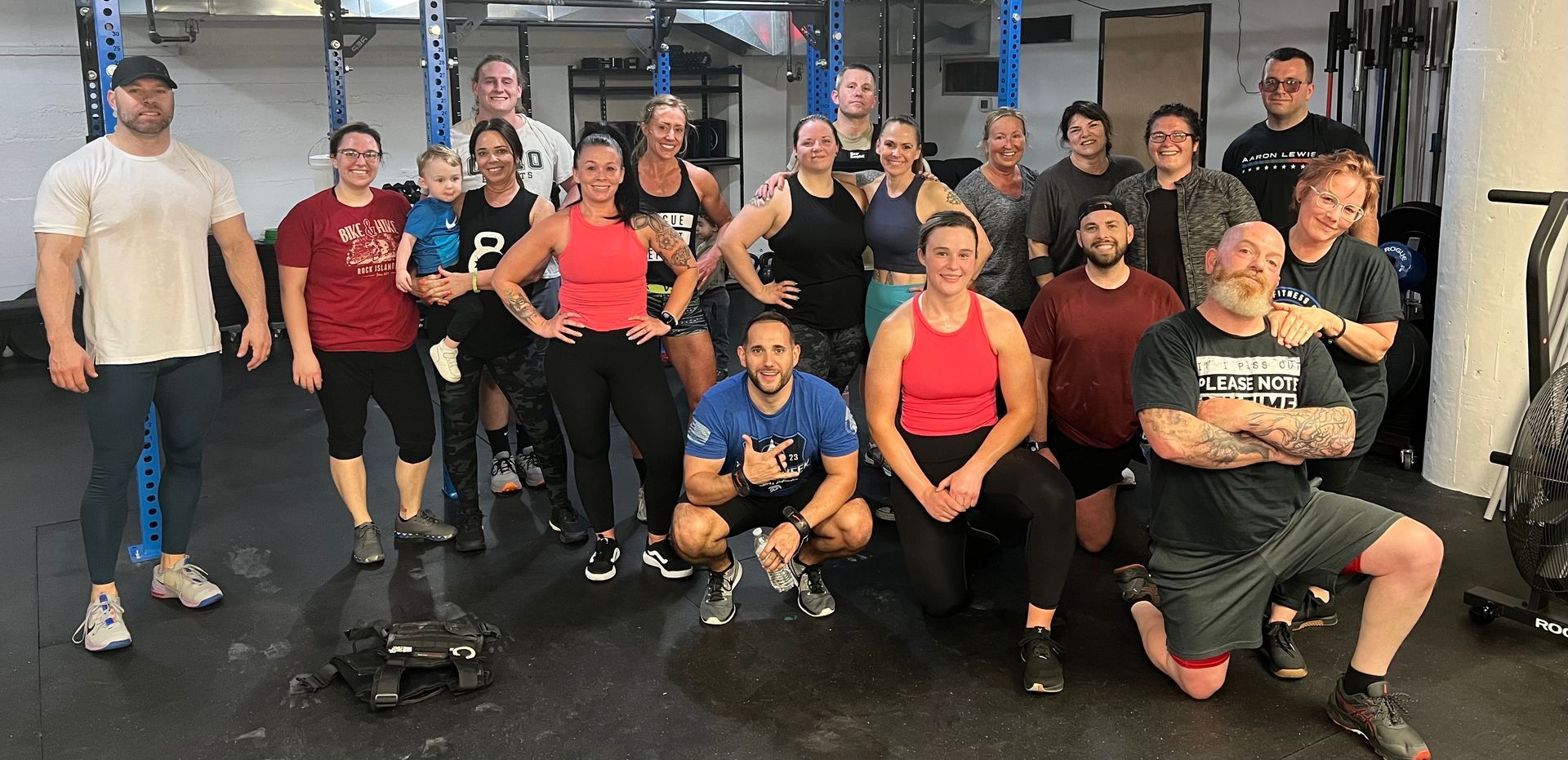 A group of people are posing for a picture in a gym.