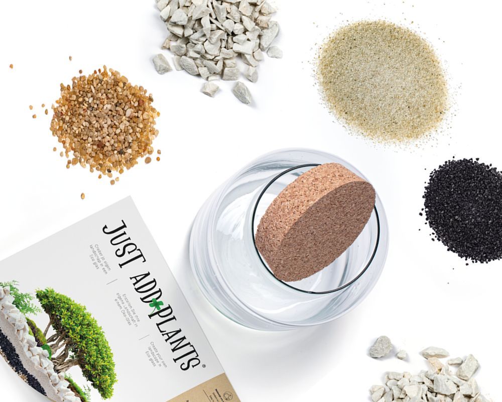 Benodigdheden voor een terrarium: glazen pot, kurk, verschillende soorten grind, zand en een brochure met de titel 