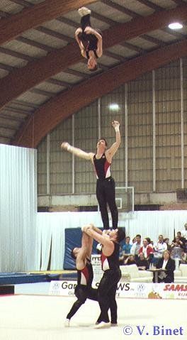 A group of people are doing a stunt in a gym.